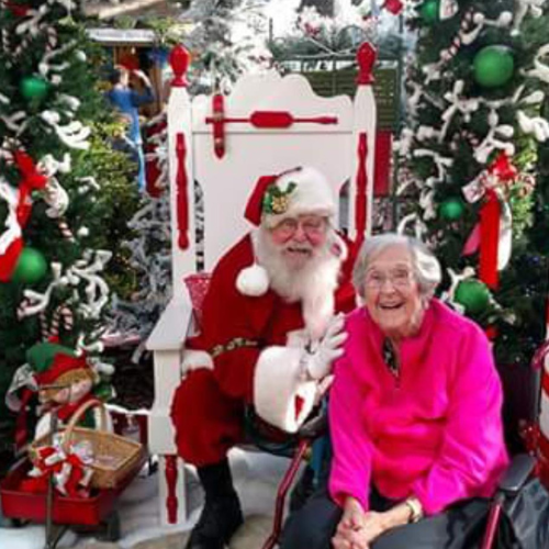 A woman posing with Santa inside of Walnut Ridge.